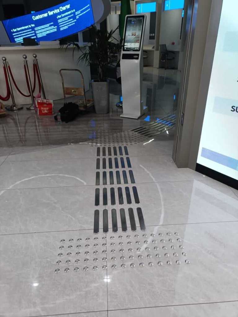 Installation of stainless steel tactile studs and directional lines on the floor of Al Barsha Government Service Center for enhanced accessibility.