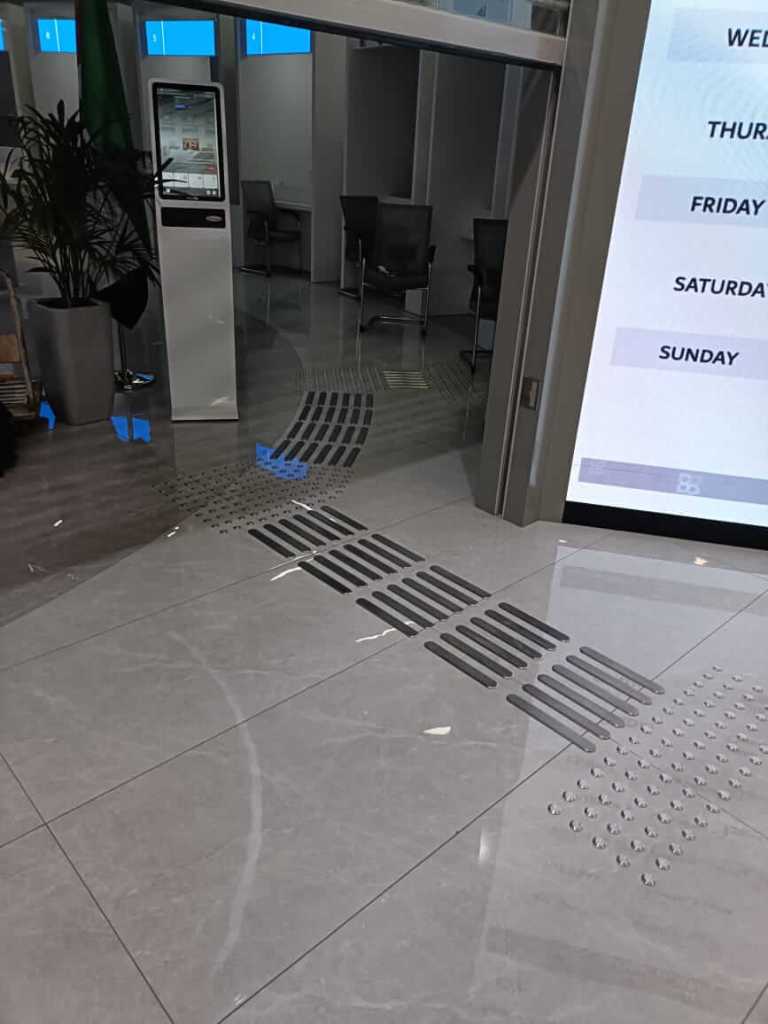 Interior view of the Al Barsha Government Service Center featuring tactile installation with stainless steel tactile studs and directional lines on the floor for enhanced accessibility.