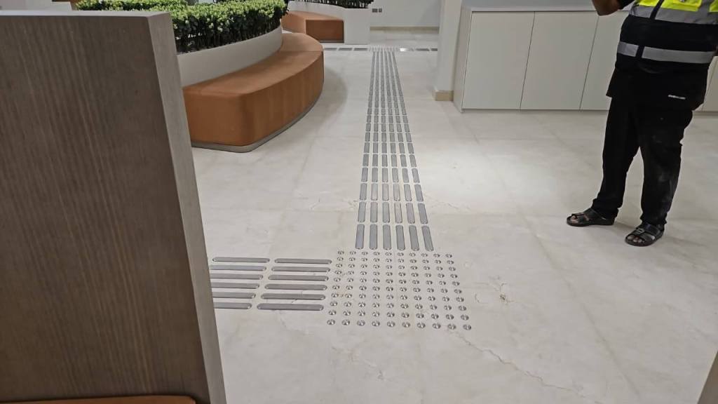 Interior view of the Dubai Court at Manara Mall featuring newly installed tactile stainless steel self-adhesive strips and studs for accessibility.