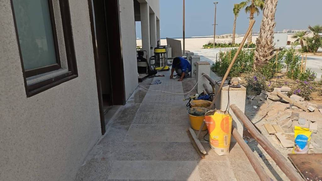 Construction site showing worker installing tactile indicators on a pathway at Majlis Al Bahar, Jumeirah.