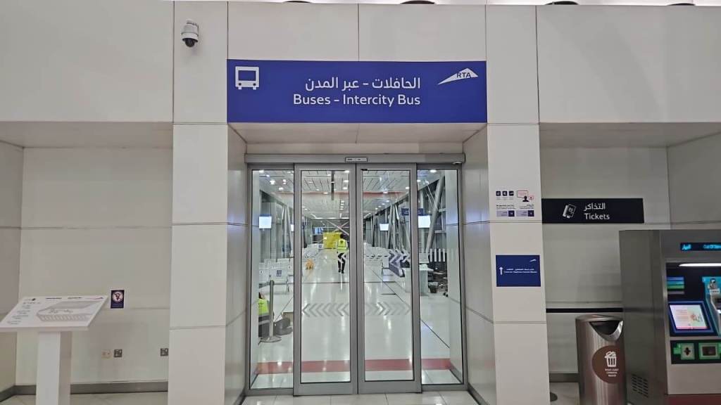 Entrance to the intercity bus station with a sign indicating 'Buses - Intercity Bus' in English and Arabic.